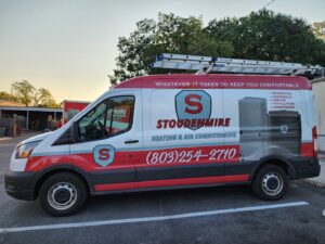 A Stoudenmire Heating & Air Conditioning service van with ladders parked in Columbia, SC, ready for HVAC jobs.