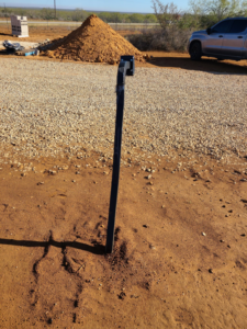 A straight metal fence post newly installed in the ground by S.A. SAF-T Systems, LLC in San Antonio, TX.