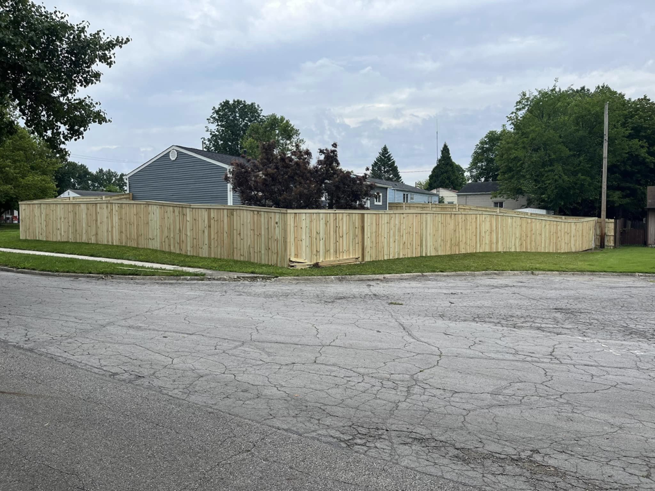A long, curving wood picket fence installed along a residential street by CDM Home Solutions in Columbus, OH.