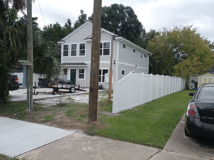 Street view of a new white vinyl fence installation by Geo's Custom Fencing, LLC for a home in Jacksonville, FL.