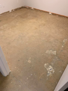 Concrete subfloor visible in a room after carpet removal by Maple Floors in Dallas, TX.