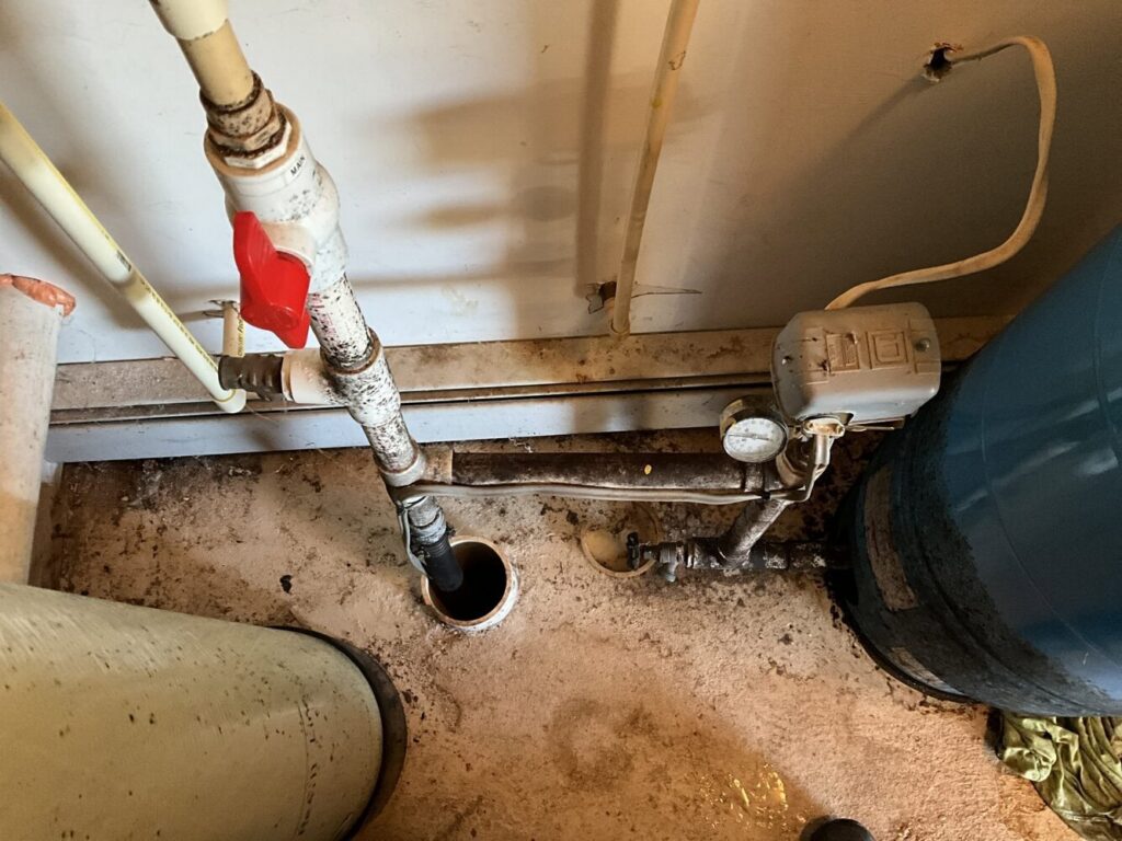 A sump pump and associated plumbing installed in a basement by Markool Heating Cooling Plumbing in Frederick, MD.