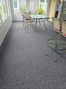 A newly installed dark gray carpet in a sunroom with outdoor furniture by FloorCrafters in Toms River, NJ