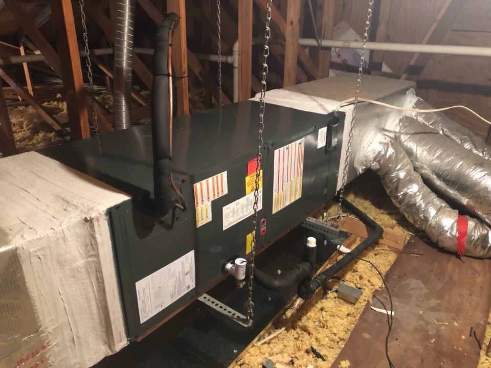 An HVAC air handler unit suspended in an attic during installation by Zippers Heating and Cooling in Mobile, AL.