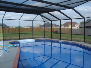 A beautiful swimming pool protected by a screen enclosure from Backyard Paradise in Mobile, AL.