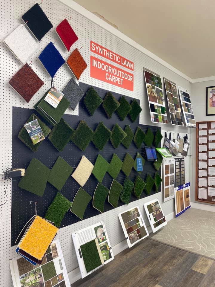 A wall display of synthetic lawn and indoor/outdoor carpet samples at Carpet King Interiors / Abbey Carpet & Floor in Fernley, NV.