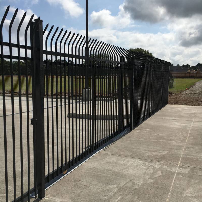 A tall black security fence with a sliding gate and pointed tops, installed by Texas Fence and Iron Co. in Houston, TX.
