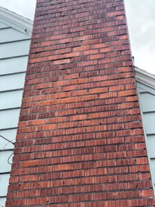 A tall brick chimney showing signs of wear before repair by Five Star Chimney Repair, an HVAC contractor in Hillsboro, OR.