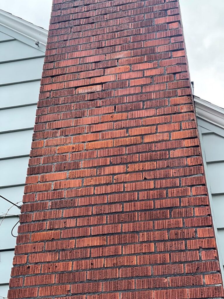 A tall brick chimney showing signs of wear before repair by Five Star Chimney Repair, an HVAC contractor in Hillsboro, OR.