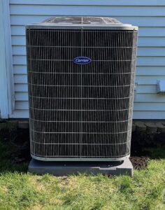 A tall, newly installed Carrier outdoor AC unit next to a home by EZ AIR HVAC in San Antonio, TX