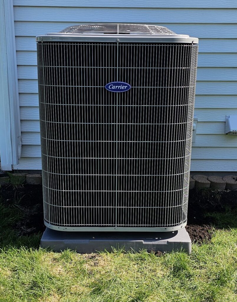 A tall, newly installed Carrier outdoor AC unit next to a home by EZ AIR HVAC in San Antonio, TX