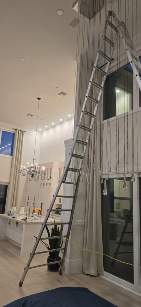A tall ladder set up for light fixture installation or repair in a high-ceiling room by Small Jobs Electric in Tampa, FL.
