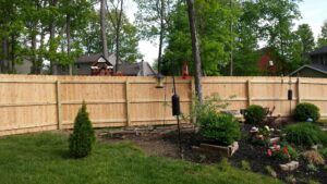 A tall wooden privacy fence installed in a residential backyard by Sharper Image Fence in Fort Wayne, IN.