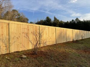 A long, tall wood privacy fence installed along a property line by Fenceitforu LLC in Matthews, NC.