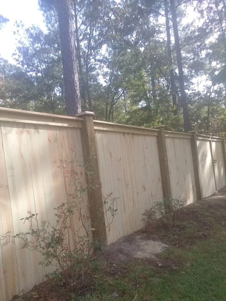 A tall wooden privacy fence installed along a property line by Rowe Fence & Supply in New Kent, VA.