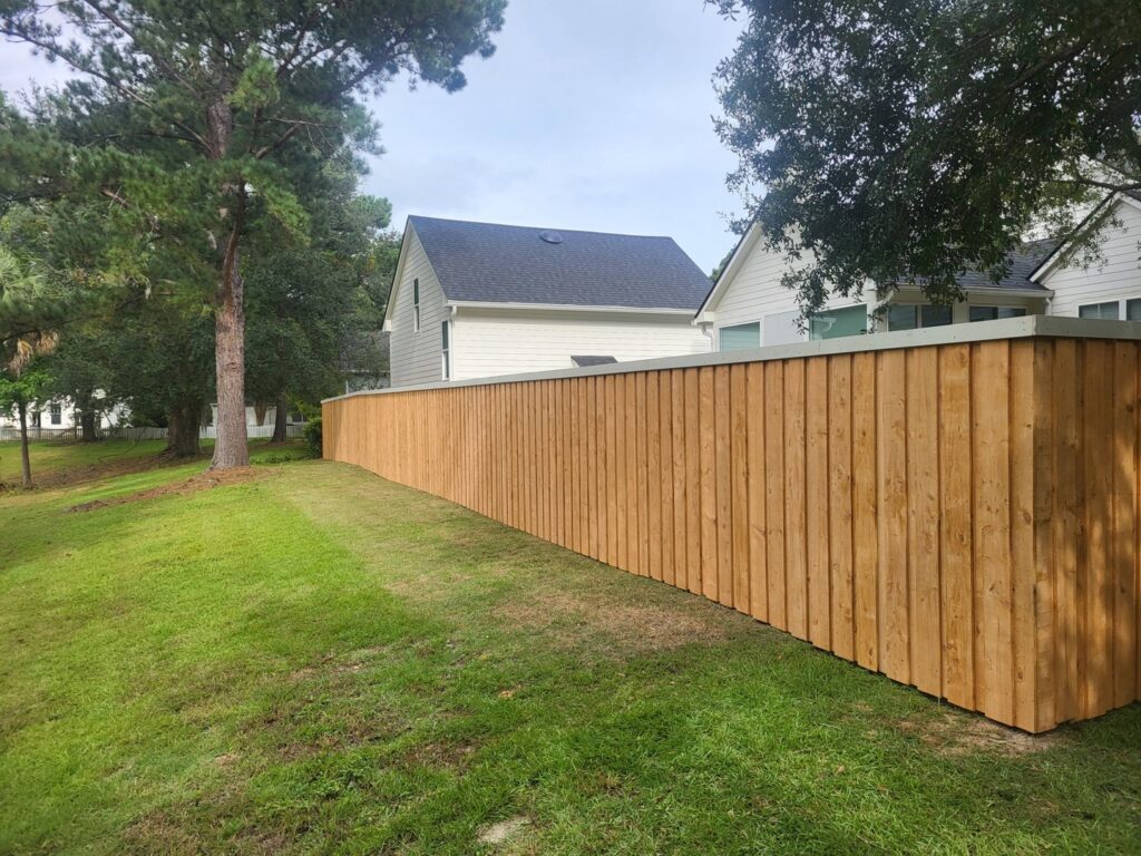 A tall wooden privacy fence installed along a residential property by JB FENCE Brothers company llc in North Charleston, SC.