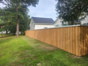 A tall wooden privacy fence installed along a residential property by JB FENCE Brothers company llc in North Charleston, SC.