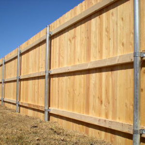 A tall wood privacy fence with sturdy metal posts installed by Pick-It Fences LLC in Pflugerville, TX.