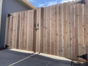 A newly installed tall wooden privacy fence with a double gate, completed by North CO Fence & Deck in Greeley, CO.