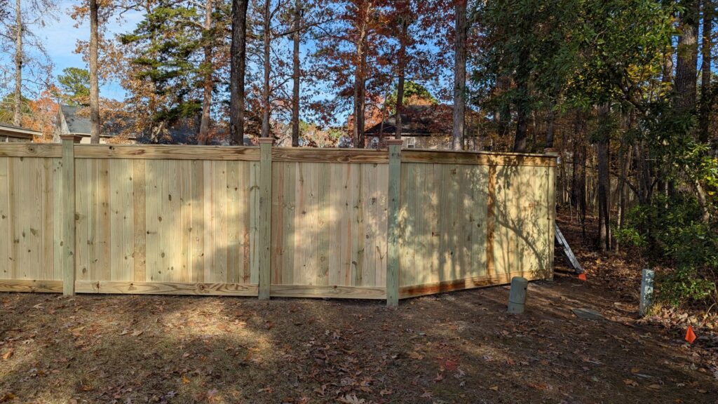 A tall wooden privacy fence installed along a property line by Gifford Contracting & Repair - Custom Privacy Fencing in Goose Creek, SC.