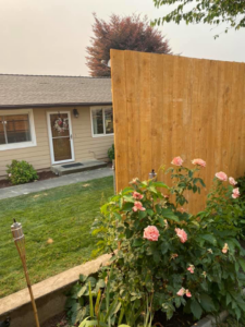 A tall wooden privacy fence installed next to a residential home by Ram fence in Lewiston, ID