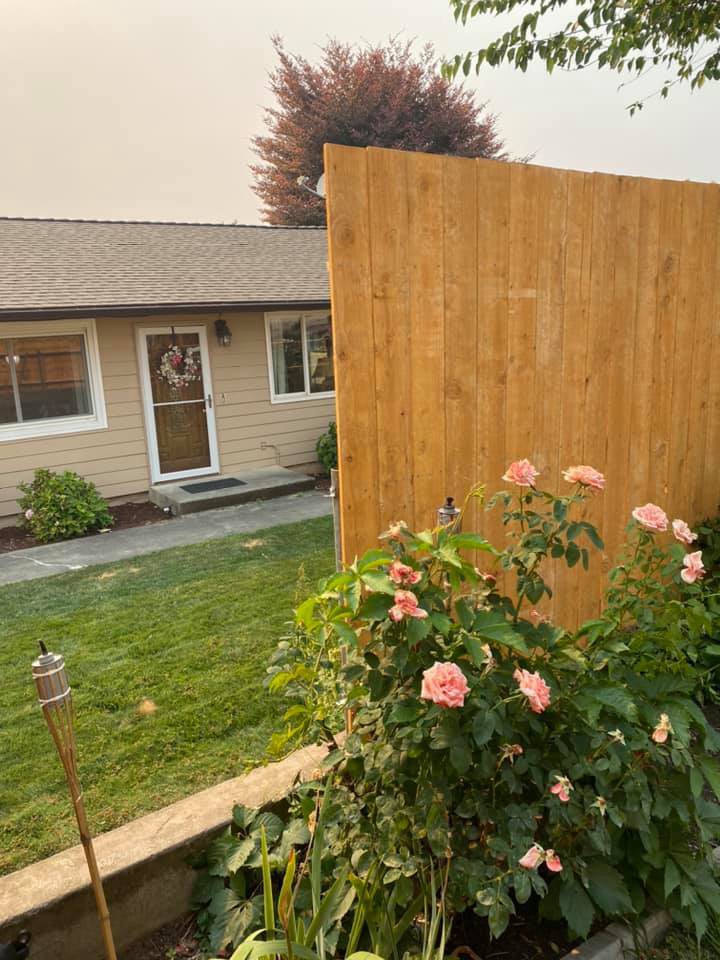 A tall wooden privacy fence installed next to a residential home by Ram fence in Lewiston, ID