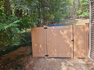 A newly installed tan privacy fence gate next to a residential home by Meyers Fence Company in Kent, OH