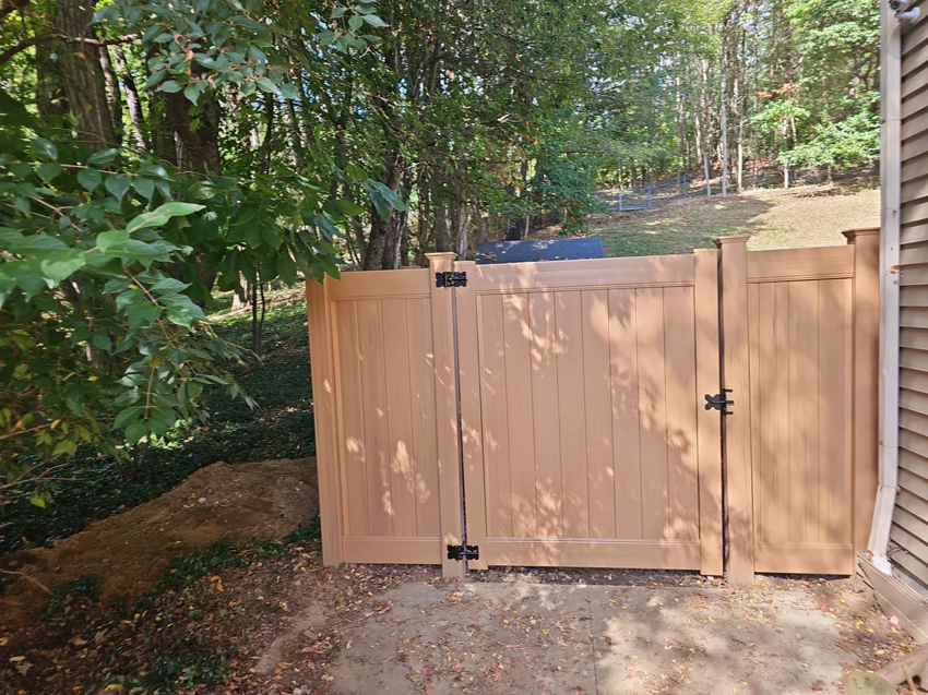 A newly installed tan privacy fence gate next to a residential home by Meyers Fence Company in Kent, OH