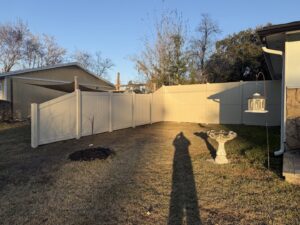 A tan vinyl privacy fence installed in a residential backyard by Masters Fence Contracting in Jacksonville, FL.