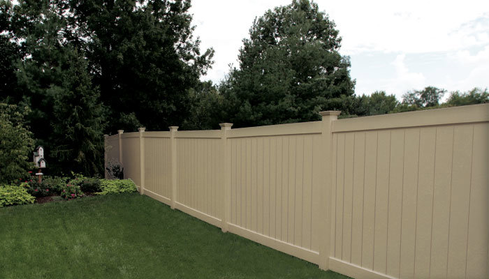 A tan vinyl privacy fence installed in a residential backyard by Western Fence & Landscape Supply in Caldwell, ID.
