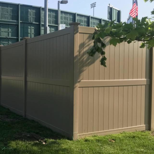 A tall tan vinyl privacy fence installed by Mercer Fence Company, providing seclusion in Hamilton Township, NJ.
