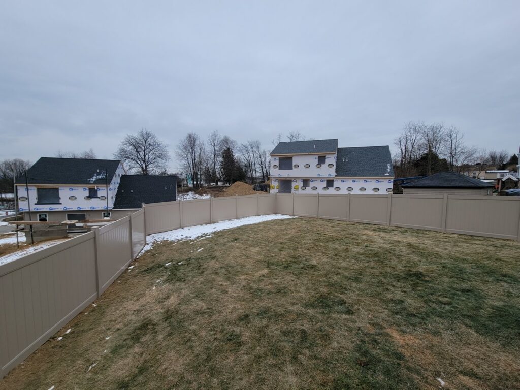 A tan vinyl privacy fence installed around a new construction backyard by Hitz Fence in Lebanon, PA.