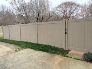 A tan vinyl privacy fence with a single gate installed by Outsiders Fencing in Greensboro, NC.