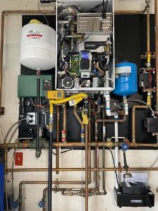 An intricate tankless water heater and hydronic piping system installed by Air We Are in Toms River, NJ.