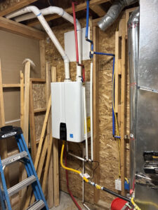 Installation of a tankless water heater with visible HVAC ductwork by Diamond L Plumbing & HVAC in Salt Lake City, UT.