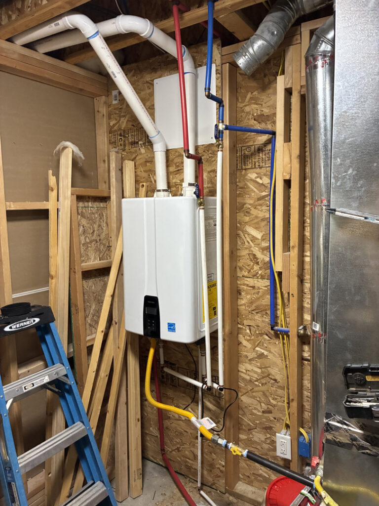 Installation of a tankless water heater with visible HVAC ductwork by Diamond L Plumbing & HVAC in Salt Lake City, UT.