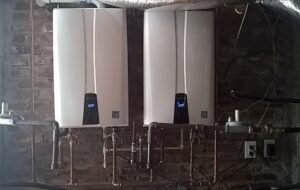 Two tankless water heaters installed on a brick wall by Honesty Services in Rock Hill, SC.