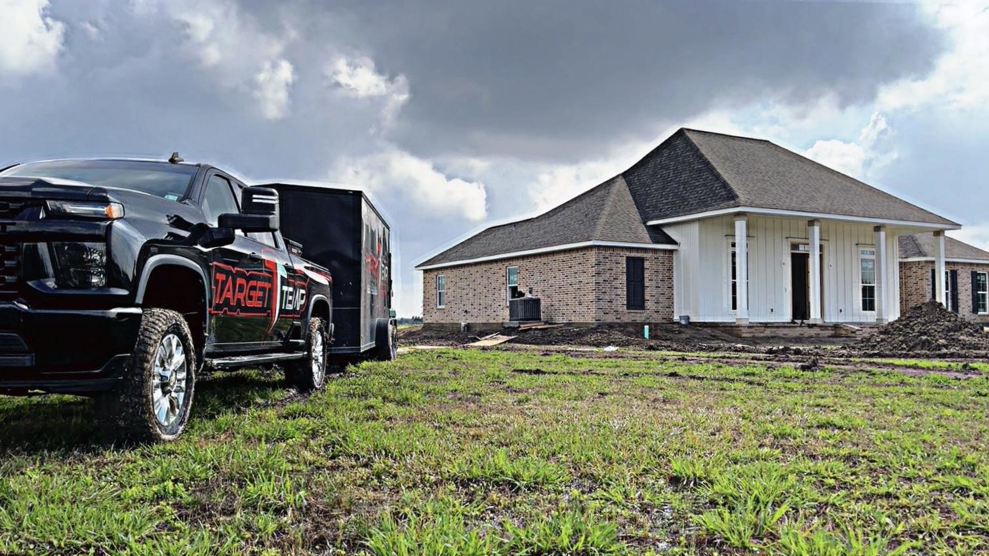 A Target Temp, LLC service truck and trailer parked at a new construction home site in Houma, LA.