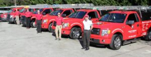The team and fleet of red wildlife removal trucks from Xceptional Wildlife Removal Jacksonville, FL, ready for service.