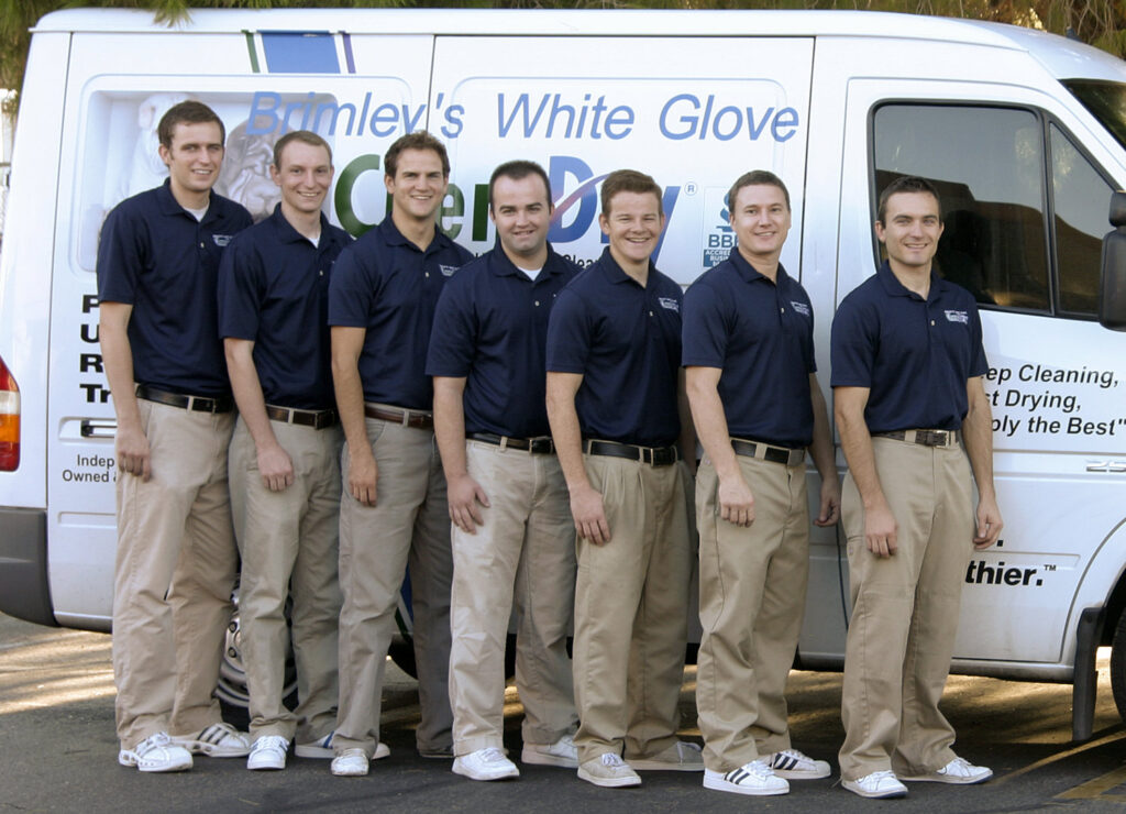 A team of Brimley's White Glove Chem-Dry technicians stands in uniform in front of a service van in Mesa, AZ.