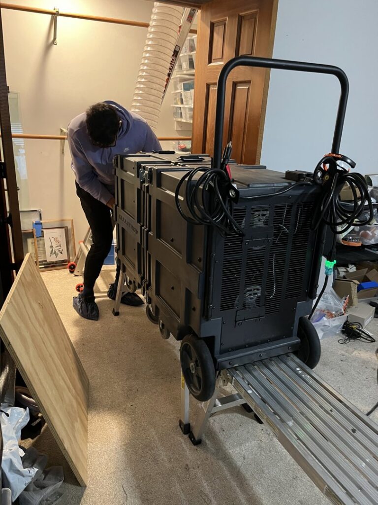 A technician adjusting duct sealing equipment on a ladder for Green Seal Energy in Overland Park, KS.