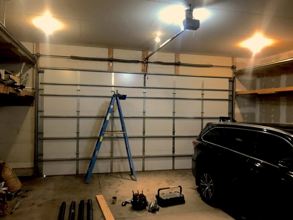 A technician on a ladder adjusting a garage door opener for Align Garage Door in Ringgold, GA.