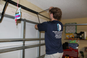 A Chase Door Systems technician adjusting a garage door spring in Summerville, SC.