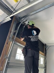 A Chase Door Systems technician adjusting garage door tracks and rollers in Summerville, SC.