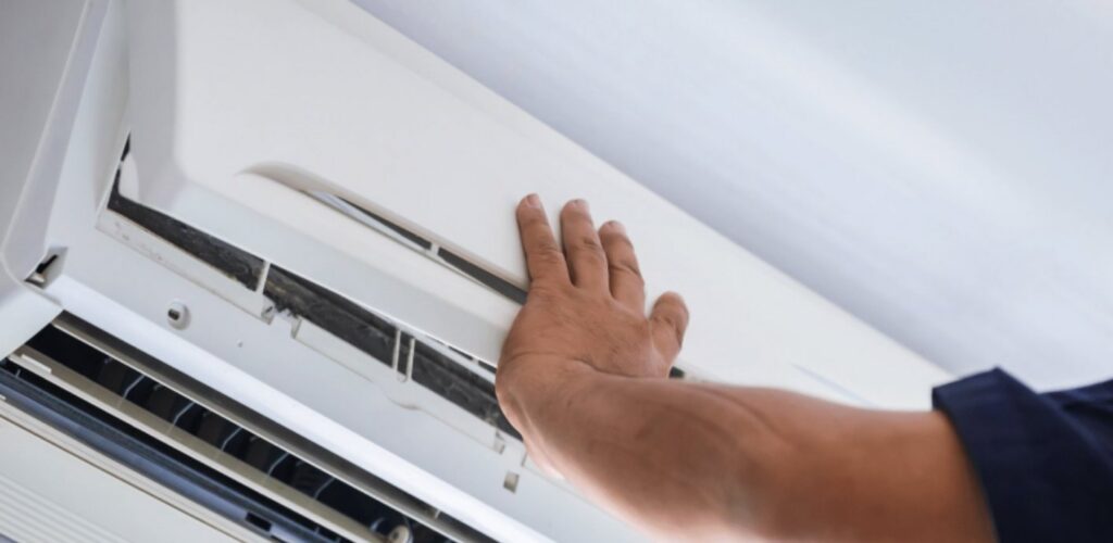 A technician adjusting an indoor split air conditioning unit for Husky Heating and Cooling in Westminster, CO.