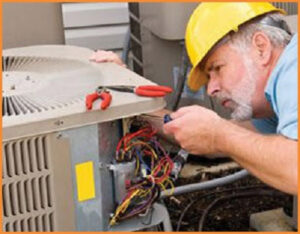 A technician adjusting controls on an indoor boiler or furnace unit, performing service for Stevens Refrigeration & Heating in Enid, OK