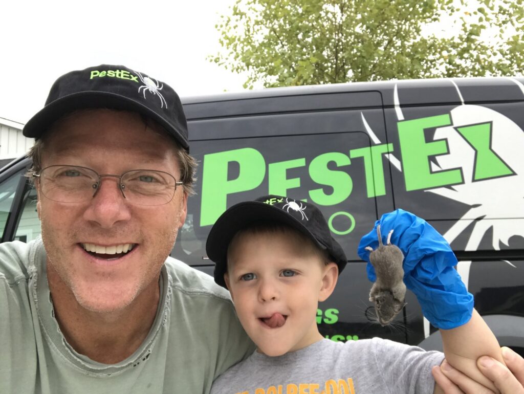 A PestEx Idaho technician and a child holding a mouse, showcasing successful wildlife removal services in Boise, ID.
