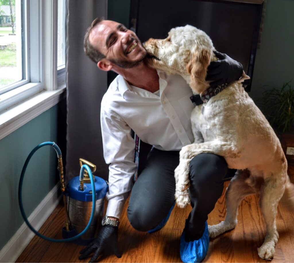 A pest control technician applying treatment along a baseboard inside a home for Clark's Classic Pest Control in Nashville, TN.