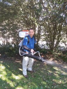 A pest control technician using a backpack sprayer for mosquito control services at Mosquito Eliminators in Hattiesburg, MS
