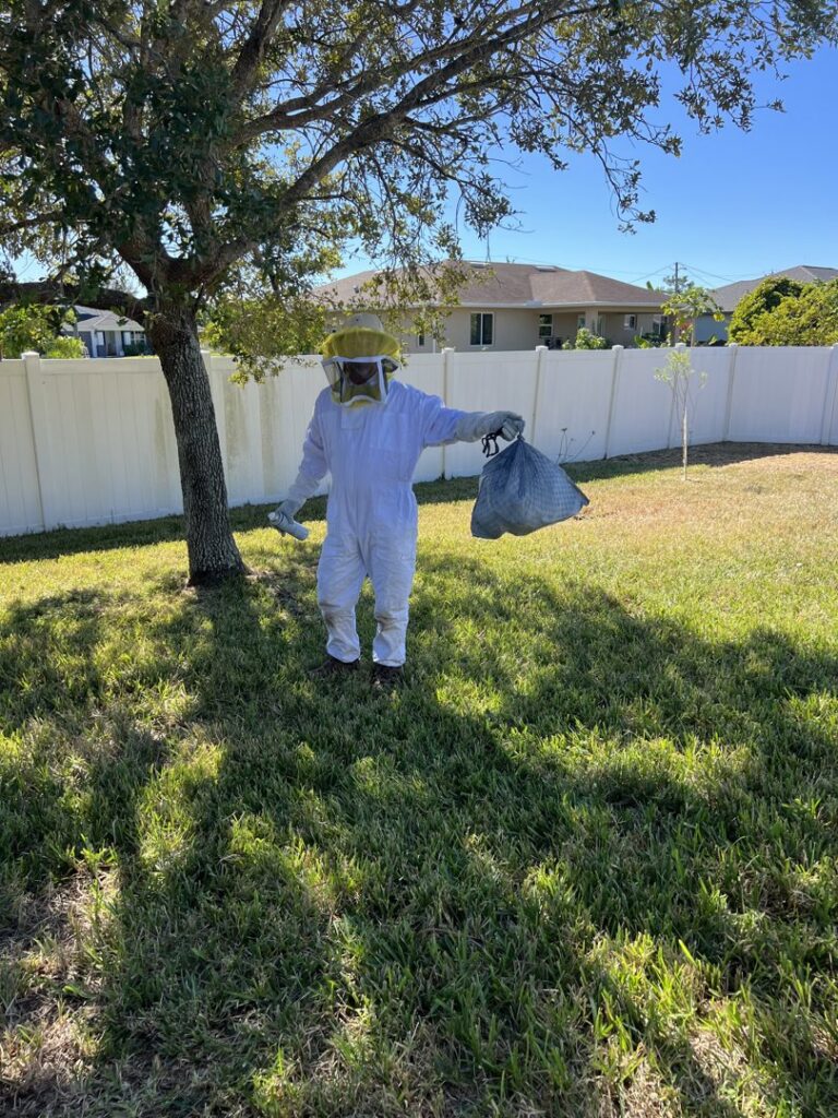 A Paske Pest Control & Wildlife Solutions technician in a full bee suit for bee or wasp removal in Cape Coral, FL.